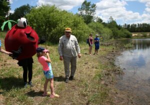 Little Girl Fishing in pond with Cranberry Guy standing on shore